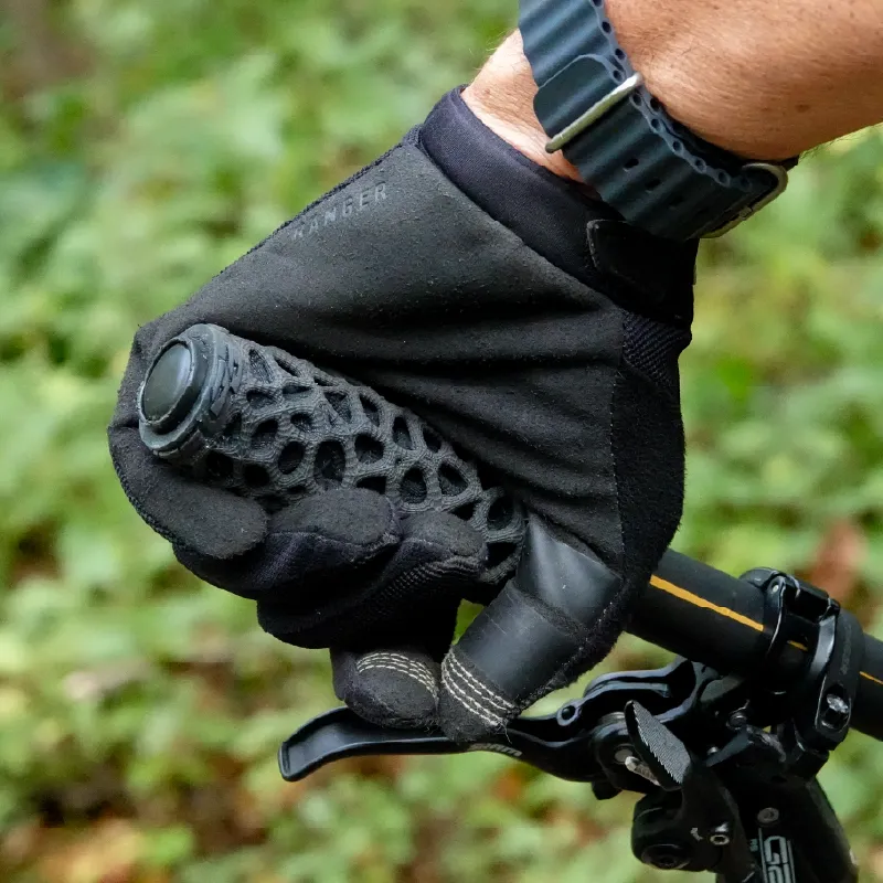 A gloved hand gripping an ExoGrip on a mountain bike handlebar outdoors
